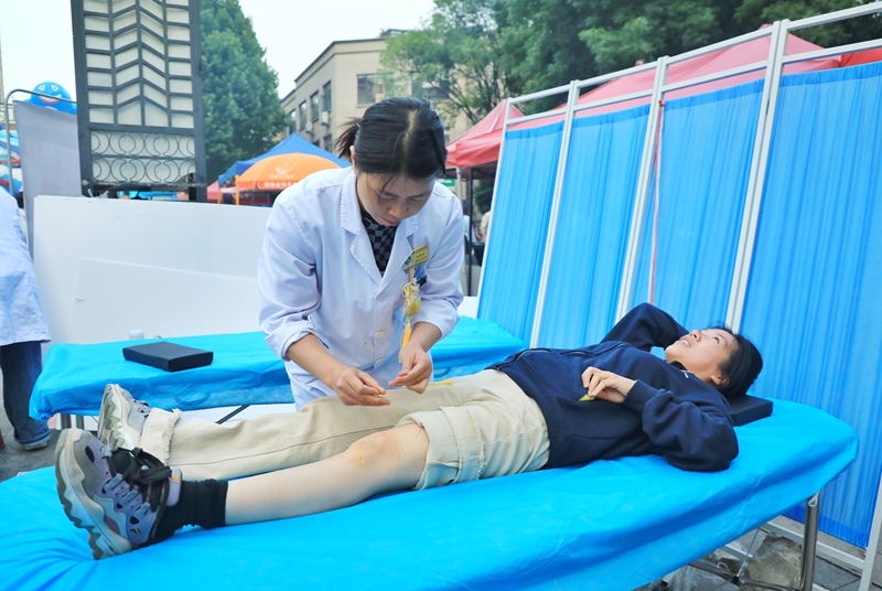 4 义诊现场,中医师根据居民身体情况开展针灸等特色中医理疗服务。